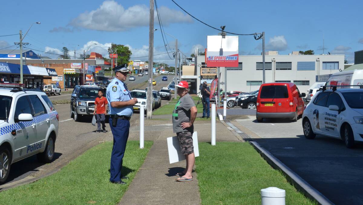 Move along: Inspector Shane Cribb moves protestor John Starr on from in front of the Coles Express service station on Gordon Street yesterday.