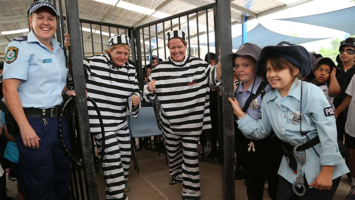 GRIFFITH: Doing time on Wednesday at Griffith Public School are assistant principal Trish Campbell and principal Jude Hayman, thrown in the slammer by PCYC's senior constable Pete Naisby with back up from Sophia Kelsey, 8 and Senay Kunduz, 9. They helped raise funds for Griffith PCYC's Time4Kids. Picture: Anthony Stipo/The Area News