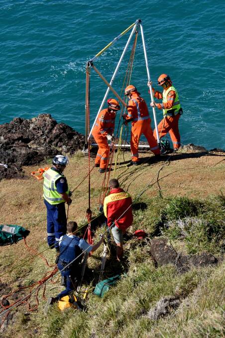 Delicate operation: Members of Port Macquarie SES set up the Larkin Frame equipment to retrieve the fallen man. Photo: Ivan Sajko