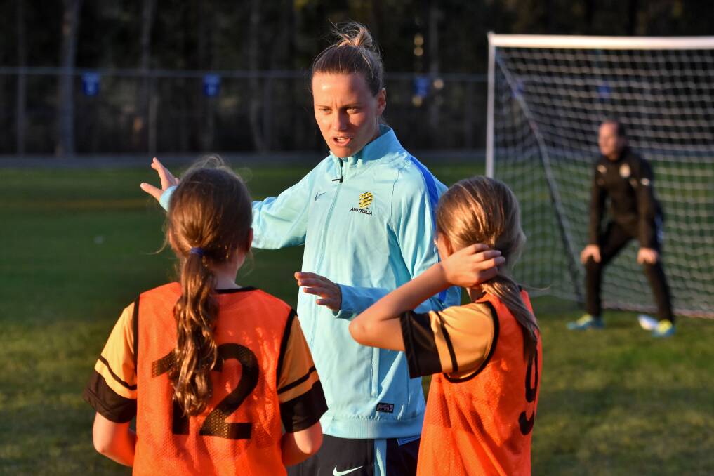 Special instructions: Matilda player and professional footballer Emily van Egmond speaks with under 8s Football Mid North Coast players in Port Macquarie on Tuesday. Photo: Matt Attard