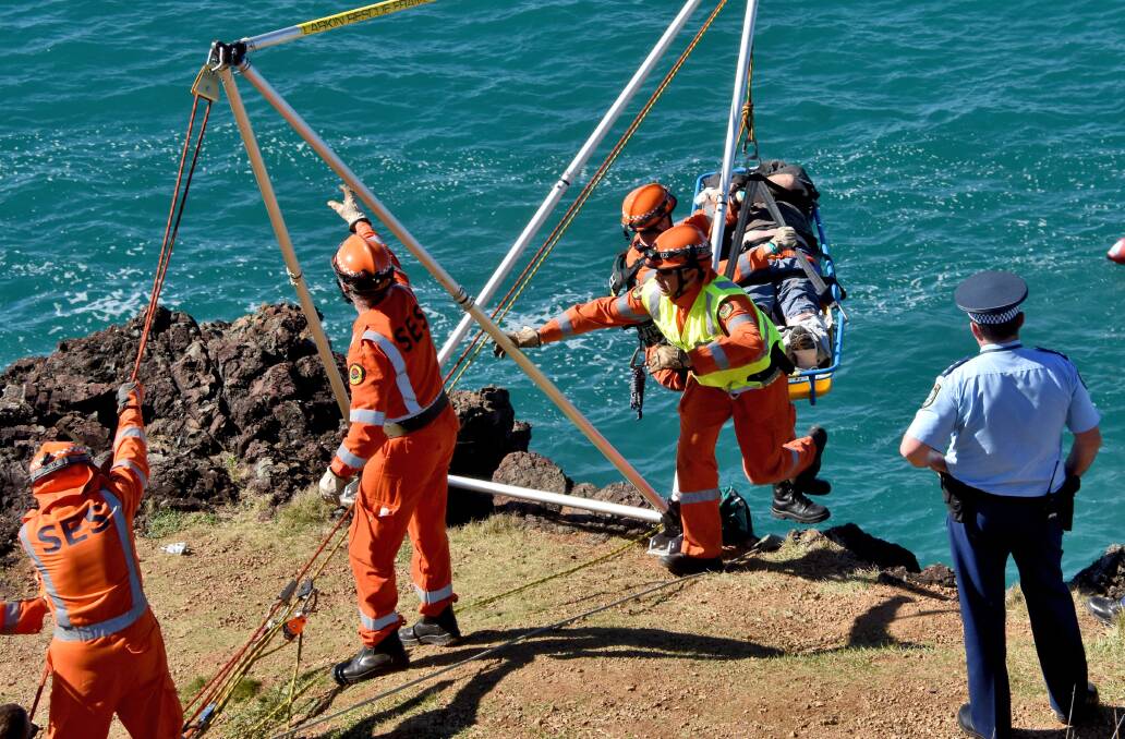Rescue mission: Members of Port Macquarie SES retrieve the injured rock fisherman on Monday. Photo: Ivan Sajko.