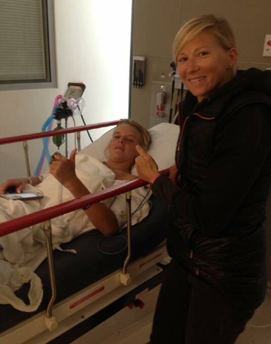 Resting up: Levi Kelly in hospital with friend and coach, Erin Kalkbrenner. 
Photo: Supplied