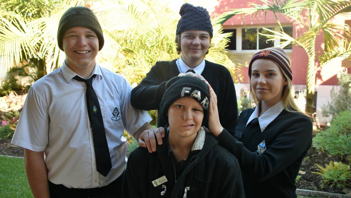 Looking good: Caleb Scott, middle, with brother Dylan Scott (left), and students Mason Matts and Lara Hickey wear beanies to fundraise for brain cancer awareness and research. Photo: Matt Attard