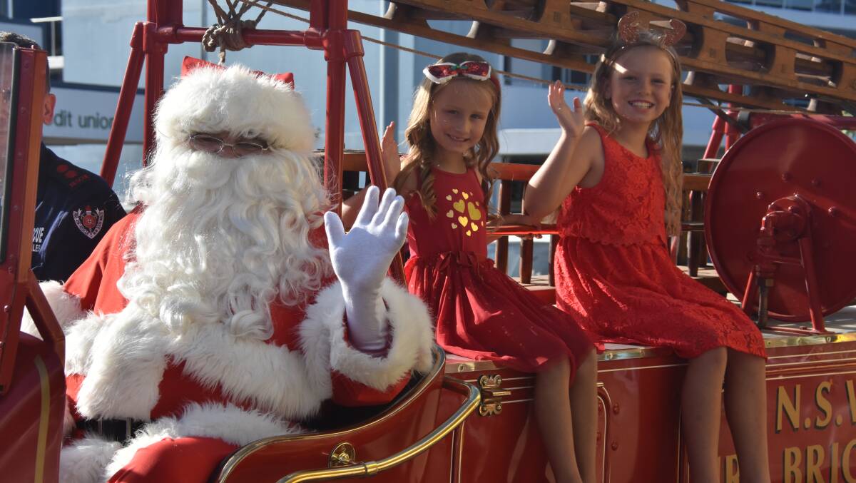 Ho ho ho: Jorja and Millie Paine hitched a ride with Santa Claus at the Countdown to Christmas parade. Photos: Matt Attard