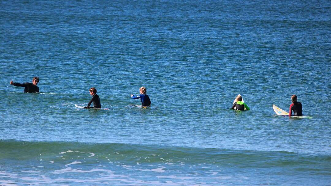 Reading the ocean: Wayne Hudson, far left, teaching kids to read the ocean. Photo: Supplied