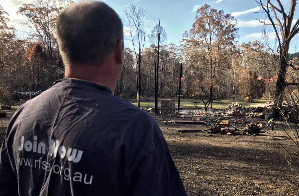Reflection: RFS deputy captain Steve Taylor looks at a house that was lost in the fires. Photo: Matt Attard