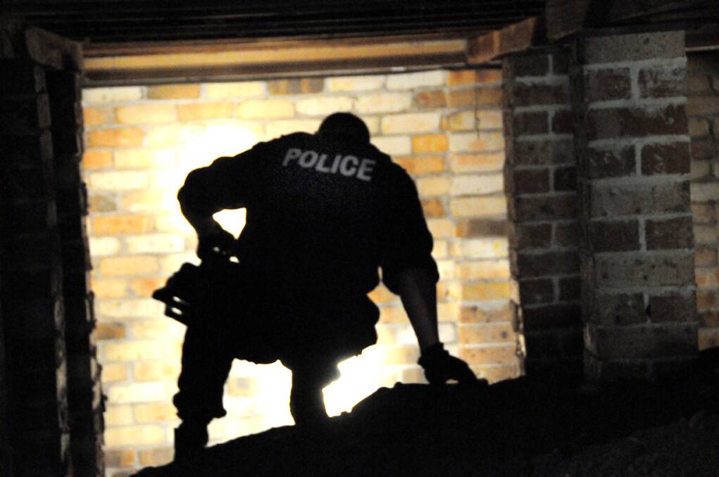 A long investigation: Senior Constable Paul Slater searching for further evidence in the case against the Galbraith brothers back in August, 2011. Police were attempting to locate weapons allegedly buried under a Greenmeadows home.