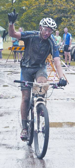 A mud-splattered Jason English crosses the finish line.