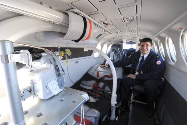 Extra space: Acting senior flight nurse Lachlan Beattie with the new bariatric stretcher inside the Beechcraft King Air 350. 