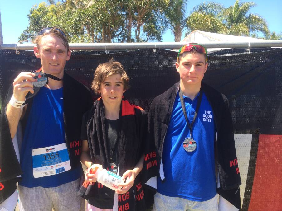 Local champs: The Good Guys Port Macquarie were the first local team and second overall team to cross the line. Runner Tony Green shows off his medal with swimmer Sam Lewis and cyclist Liam Magennis.