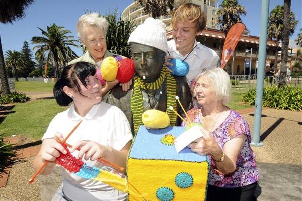 Caitlin Buggan and Fabian Hesselmans, from Port High, with knitters Desiree Hodgson and Margaret Symonds, try out the Edmund Barton statue is a trial for granny graffiti.