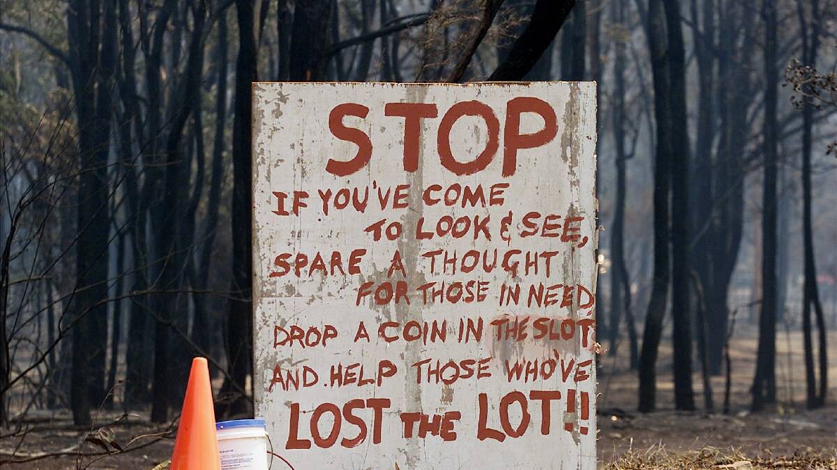 A sign asking for donations stands at the beginning of a street where six homes were destroyed by a bushfire in the township of Warrimoo in 2001. Photo: REUTERS