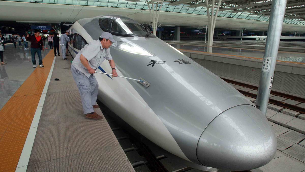 A worker cleans a CRH high-speed train at Shanghai Hongqiao Railway Station during its test run on May 11, 2011 in Shanghai, China. Photo: Getty Images