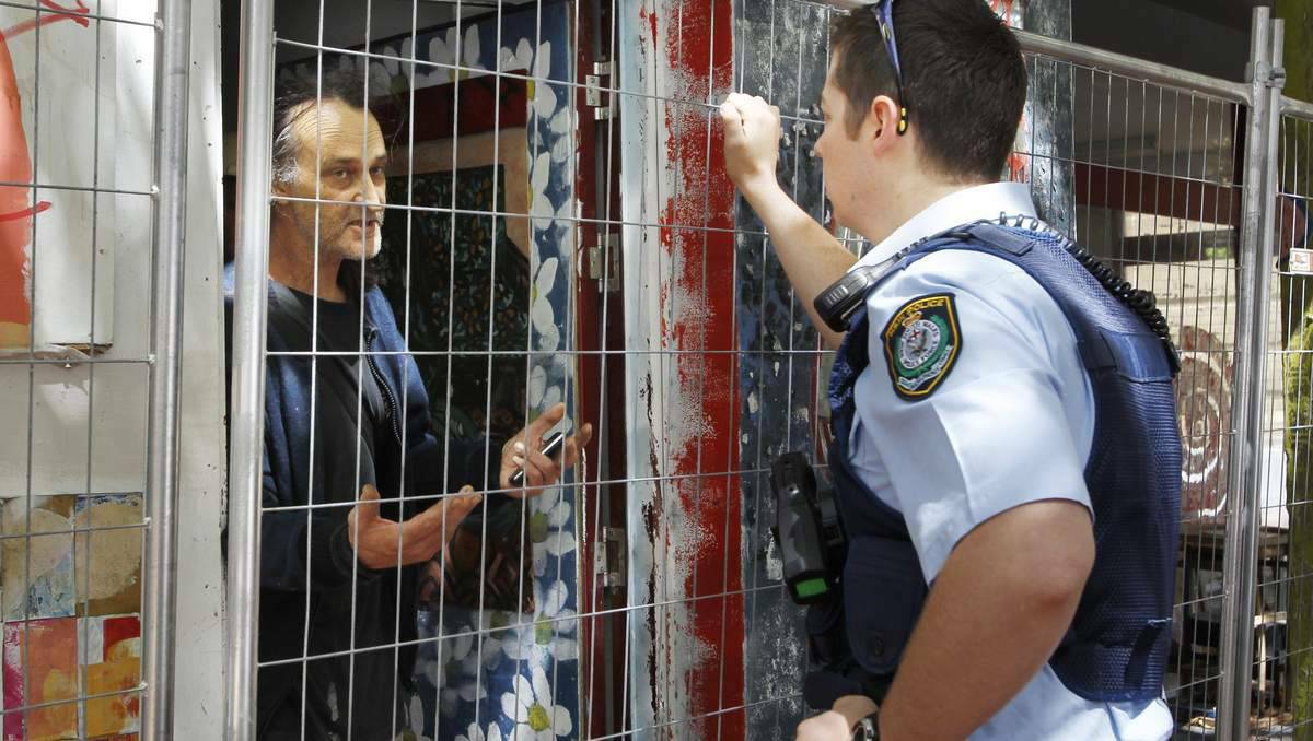 A police officer speaks to long-time occupant David Wilkinson, who is refusing to leave the Star Hotel building. Photo: ANITA JONES