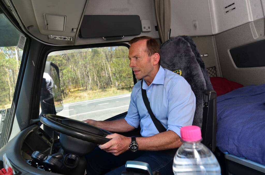 Opposition leader Tony Abbott behind the wheel in Port Macquarie today.