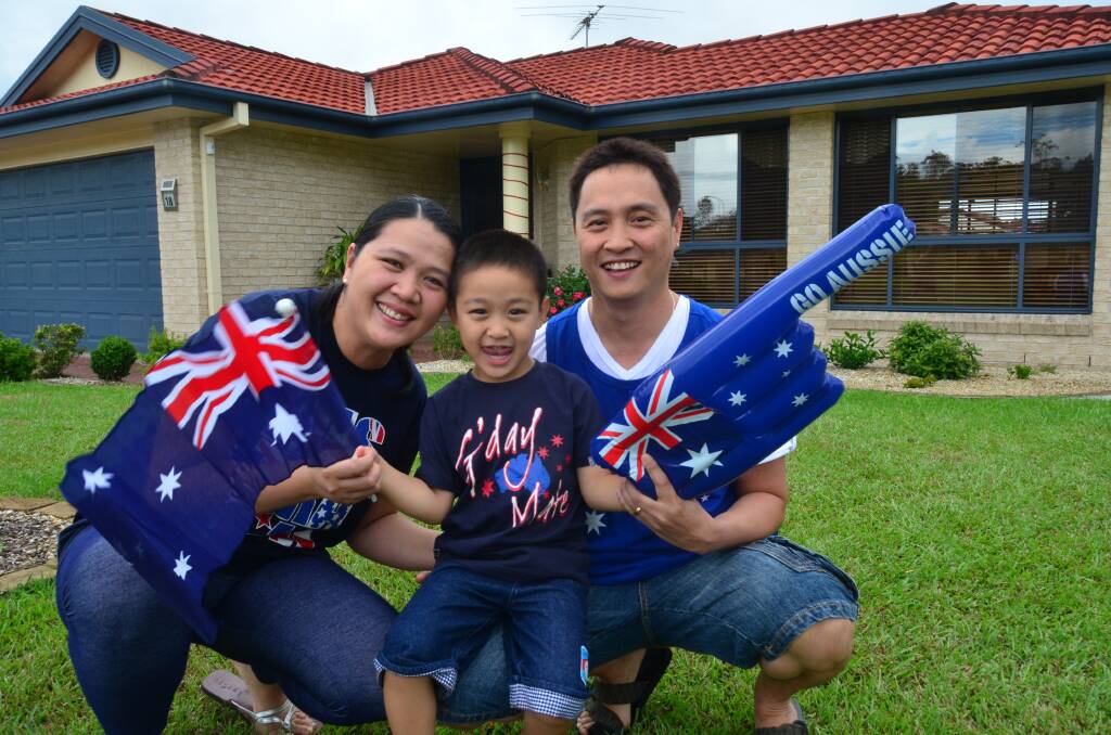 Waving in their new citizenship: Port Macquarie’s Ysaac, Mona and Rommel Nieva.