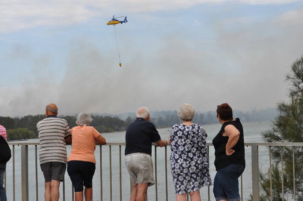 Fire tamers: Members of the Lorne, Telegraph Point and Huntingdon fire crews kept the flames at bay in the Camden Haven yesterday. As one fire was controlled, others continued to pose threats.