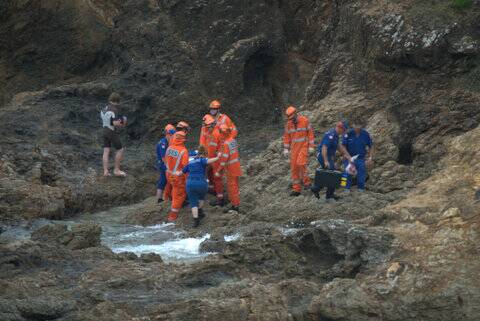 SES personnel and NSW Ambulance Service paramedics assisted the woman after she fell at Nobbys Beach on Wednesday. Pics: Christopher Nixon 0416041819.