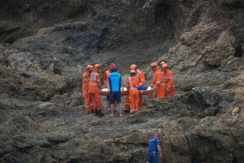 SES personnel and NSW Ambulance Service paramedics assisted the woman after she fell at Nobbys Beach on Wednesday. Pics: Christopher Nixon 0416041819.