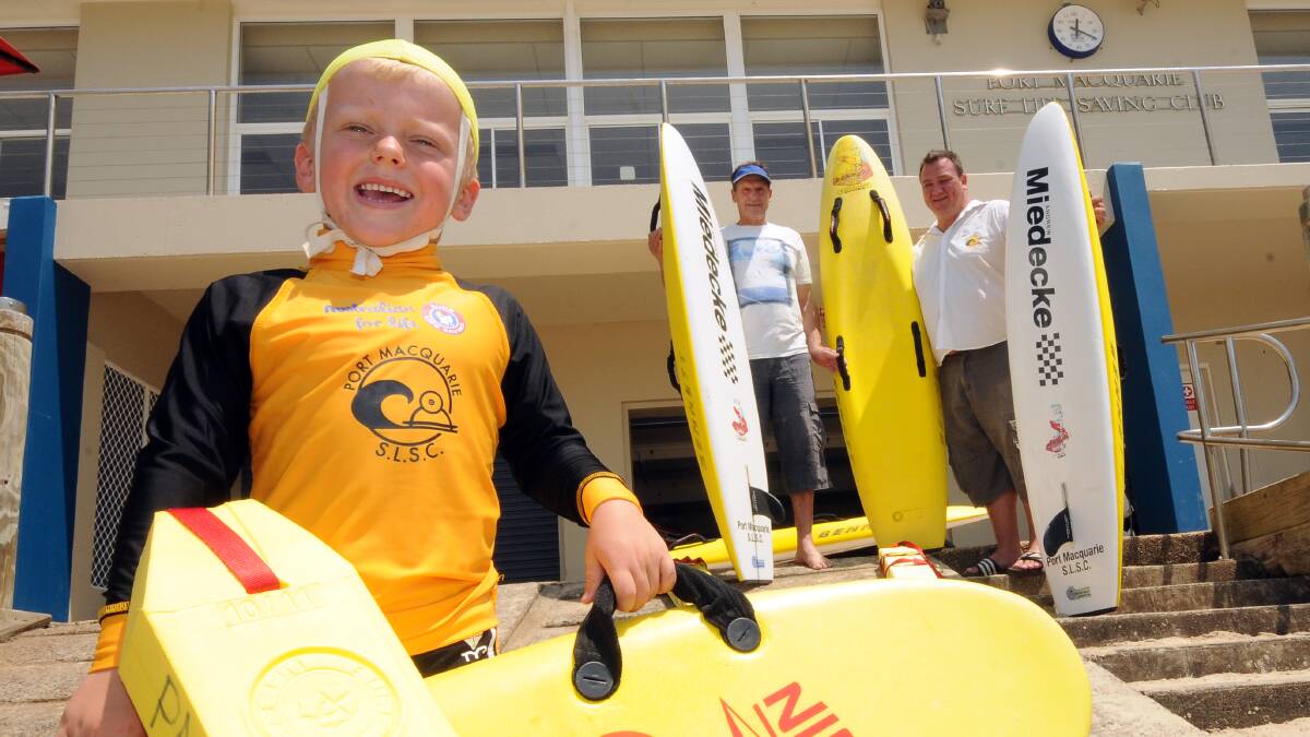 Young gun: Port Macquarie Surf Life Saving Club nipper Joshua Collins looks forward to the club’s big day next month. He’s pictured with one of the original nippers, Fred Middleton, and Ben Wehlow.