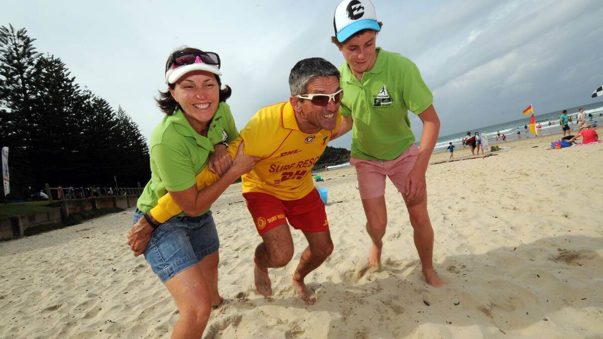 Ready to hit the sand: Jo Pilgrim and Jack Pilgrim try to hold back Port Macquarie Surf Life Saving Club’s Tony Wright ahead of tonight’s aquathon.  