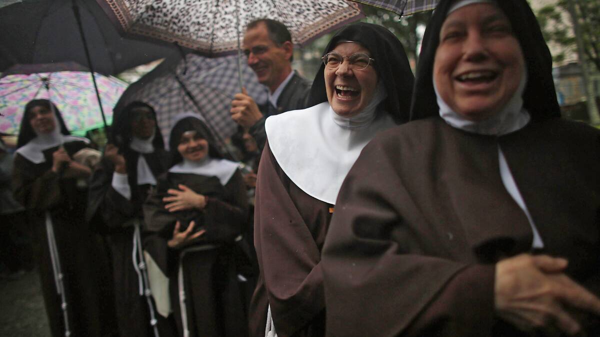 Nuns from the Nossa Senhora dos Anjos monastery wait in line in the rain to attend Pope Francis' visit to the Hospital de Sao Francisco de Assis (Hospital of Saint Francis of Assisi) on July 24 Photo: Getty Images