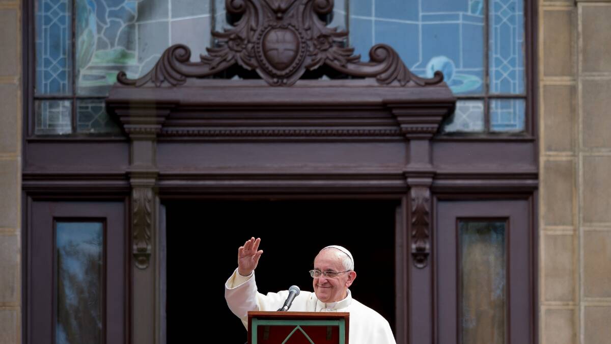 Pope Francis waves to the crowd from a balcony of the San Joaquin Episcopal Palace. Photo: Getty Images