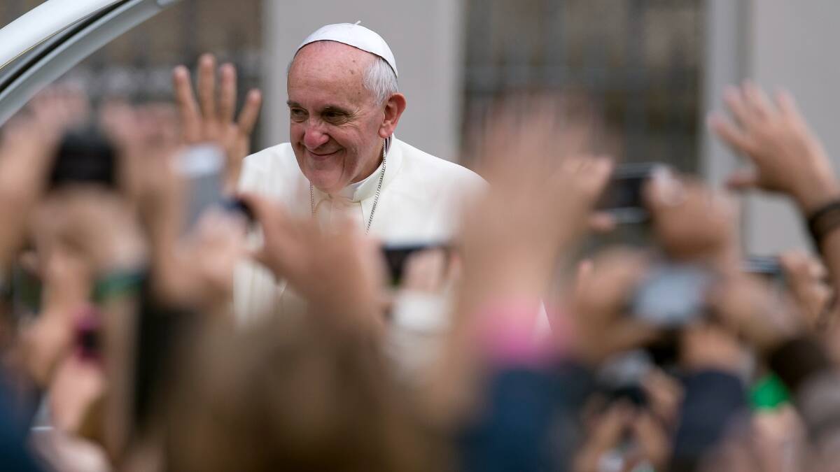 Pope Francis waves to the crowd while riding in the Popemobile on July 26, in Rio de Janeiro, Brazil. Photo: Getty Images