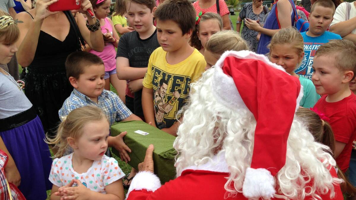 Kew Country Club kids Christmas party saw Santa arrive on the golf course in a helicopter, hand out presents to members' children and hear their Christmas wishes. Thanks to John Parrot and helicopter pilot Grant Burley for donating their time for the kids. Photo: The Camden Haven Courier.