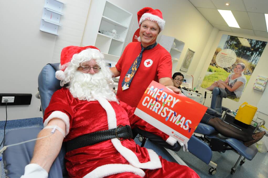 Santa giving blood at Taree Blood Bank as part of the Blood Blitz., assisted by Greg French, the Red Cross Blood Service's community liaison officer. Photo:The Manning River Times.