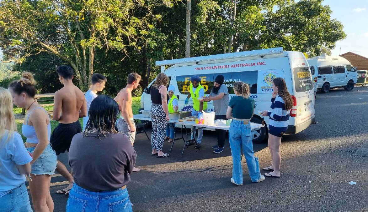 Member of Sikh Volunteers Australia hand out free meals at student accommodation in flood-devastated Lismore on Wednesday, March 2. Photo: Sikh Volunteers Australia.