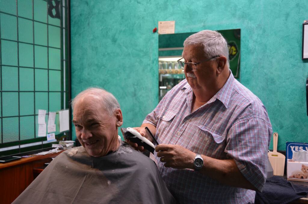 Mr Moy cuts the hair of long time customer Brian in his barber shop. Picture by Emily Walker