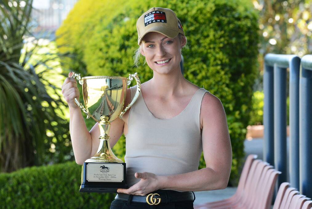 Apprentice jockey Georgina McDonnell with the Stacks Law Firm Taree Cup. She hopes to add the cup to her collection in Sunday's 2000 metre race.