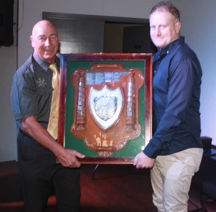 Group Three chairman Wayne Bridge presents Wauchope president Aaron Ison with the club champinship trophy at the group's award night at the Wingham Services Club. Photo Charlie Andrews.