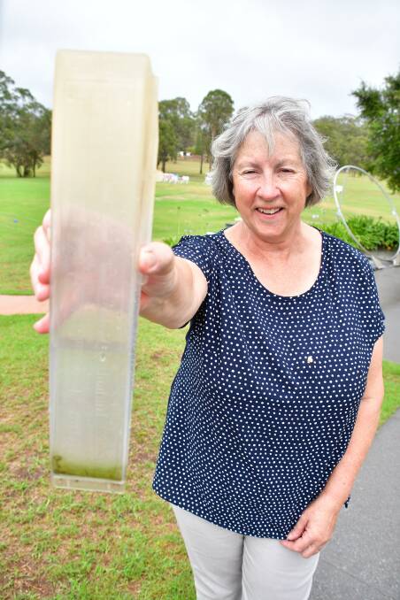 What a difference: Port Macquarie Driving Range and Mini Golf's Christine Smith checking the rain gauge at their Lindfield Park Road business on Sunday morning.