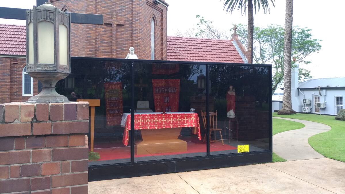 Pull over and pray: The St Agnes' Catholic Parish roadside chapel decked out in the liturgical colours of Palm Sunday, is set up and ready for 'drive-by' prayers.