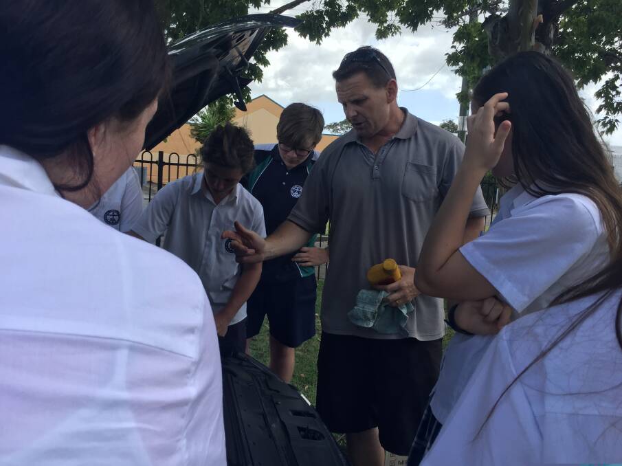 This is how it's done: Heritage Christian School teacher Luke Taylor helping unravel the mysteries of basic car maintenance to year 10 students.