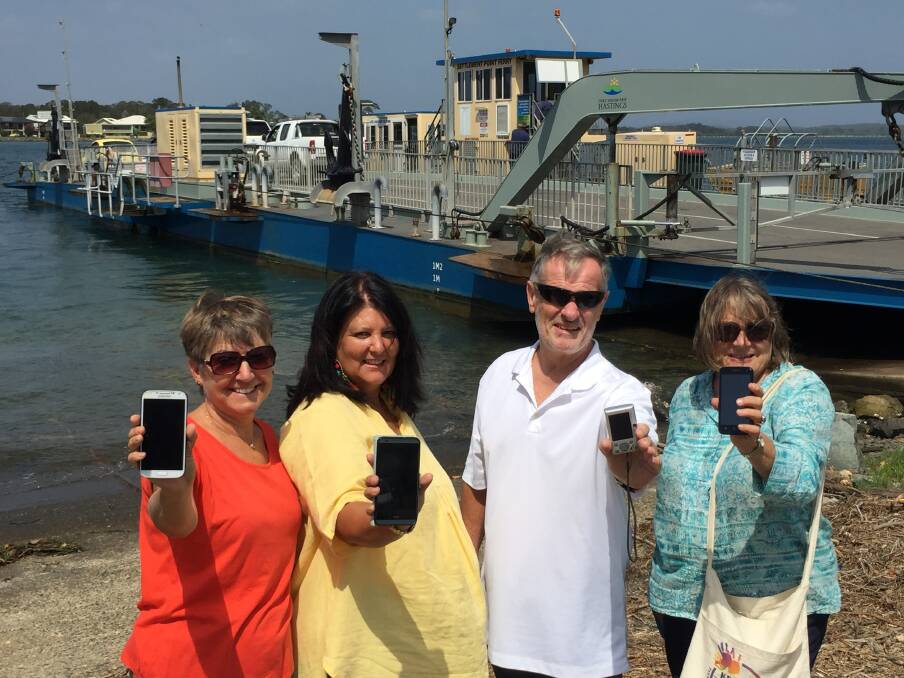 SMS alert: North Shore's Joanne Taylor Northside Progress Association president Carla McKern, Steven Taylor and association secretary Narelle Milligan celebrating the arrival of the SMS ferry alert system from March 1. Photo: Peter Daniels