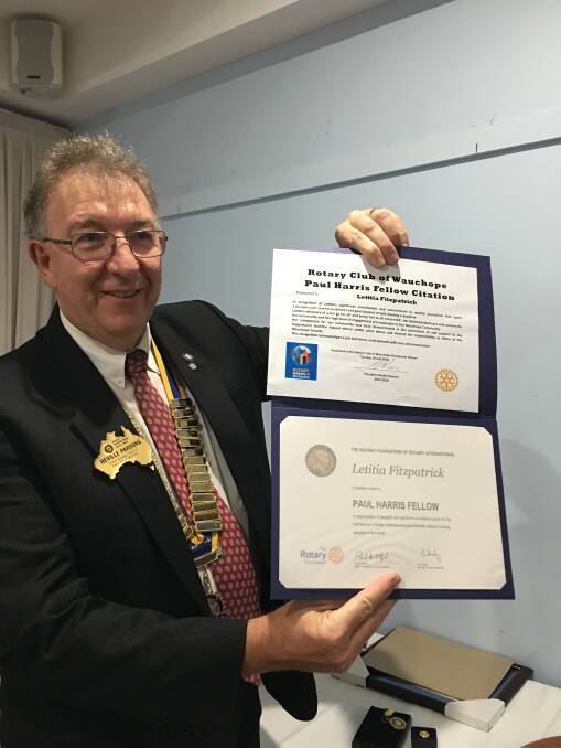 Top award: Rotary Club of Wauchope outgoing president Neville Parsons with the Paul Harris Fellow citation for Wauchope Gazette senior journalist Letitia Fitzpatrick. Photo: supplied