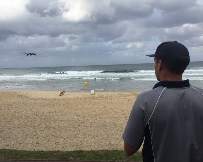 Going up: James Turnham flying a drone over Flynns Beach on Friday, April 27.
