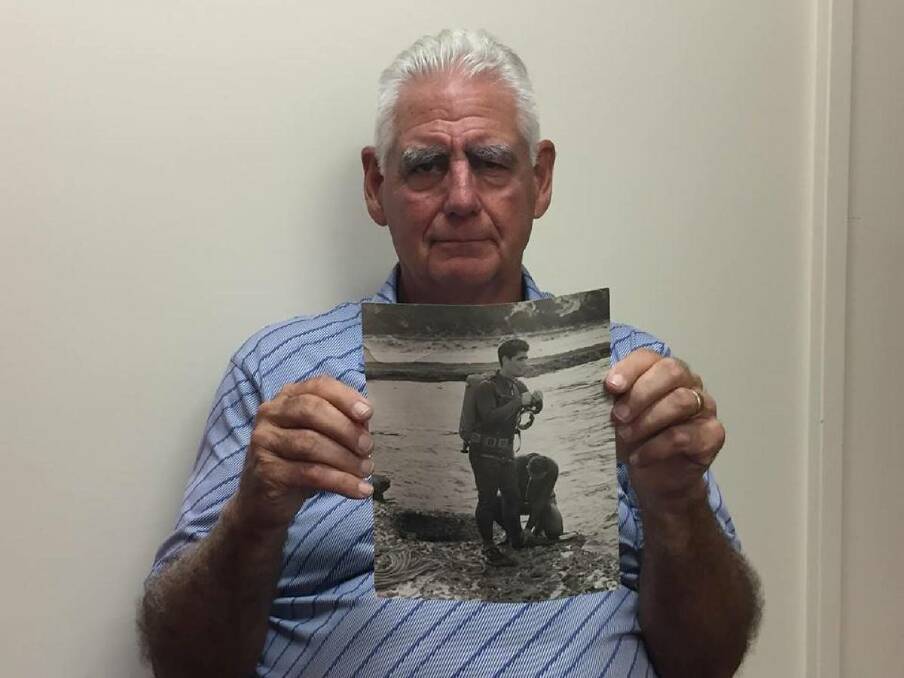Police career: John Simon holds a photo of himself as a police diver at the time of the search for Harold Holt. 