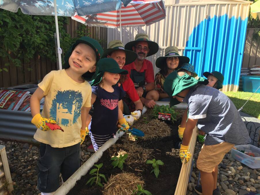 Gardening tips: Bunnings staff members Libby and Tony assisting Karen Tonkin with educating Jay, Mason, Alexander, Mason and Skylah about sustainability. Photo: Peter Daniels