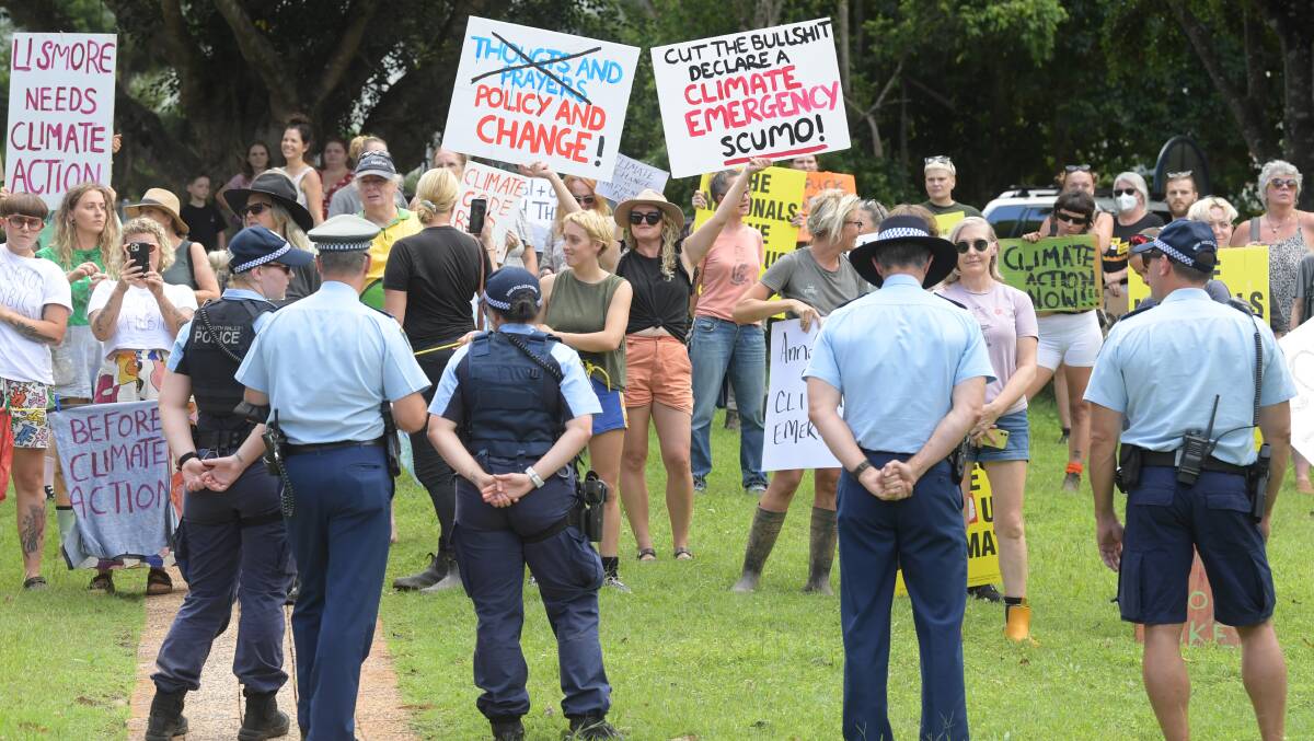 NSW Police stand in front of angry local residents as Prime Minister Scott Morrison visits the Emergency Operations Centre in Lismore on Wednesday. Picture: AAP