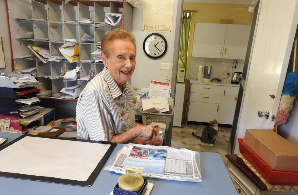RETIRING AT 87: Kath Carey at Long Flat post office with her beloved cat, Bella.