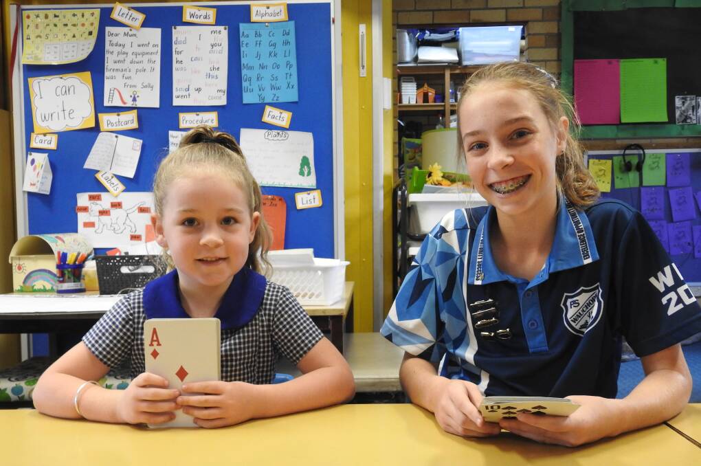 Kindy Alli Kirkman learns numbers through cards by playing Abracadabra with Sarah Garrett from Year Six.