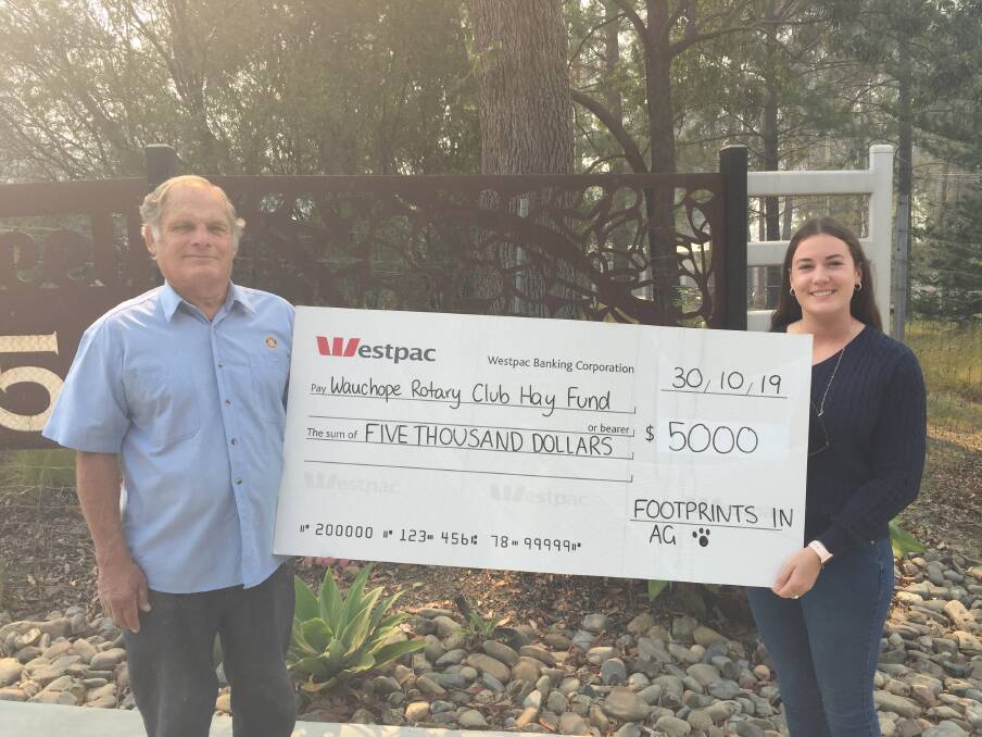 GRATEFUL: Reg Pierce from Wauchope Rotary accepts a $5,000 cheque from Footprints in Ag's Rebecca Bennett to help drought-stricken farming families.