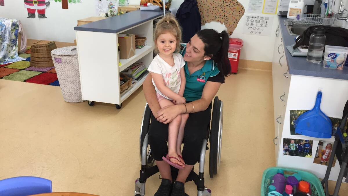 INSPIRATIONAL: Isabelle Scutt aged four cuddles up to Rosie Attard who works in TG's Childcare and has had a book written about her wheels.