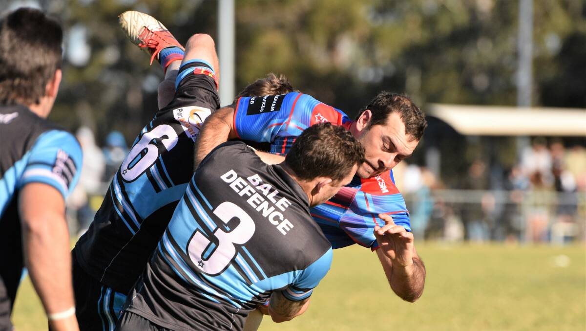 Down you go: Wauchope centre Sam Watts is up-ended by the Sharks defence on Sunday. Photo: Paul Jobber
