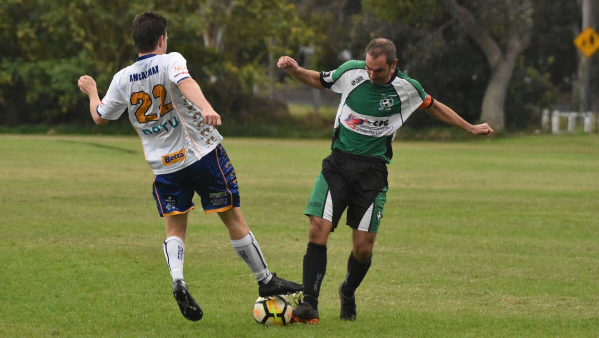 Hard challenge: Simon Granfield battles for possession in Port United's 2-0 win over Macleay Valley. Photo: Tracey Fairhurst