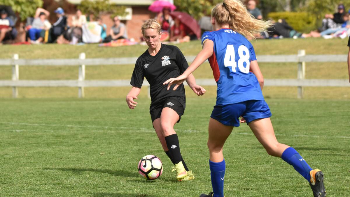 Head down: Layni Fens takes on the Newcastle Jets in a trial at Taree in October. Photo: Paul Jobber